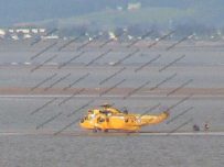 Perched on a sandbank the helicopter loads up a casualty Perched on a sandbank the helicopter loads up a casualty