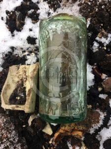 A clear glass bottle exposed after the recent floods
